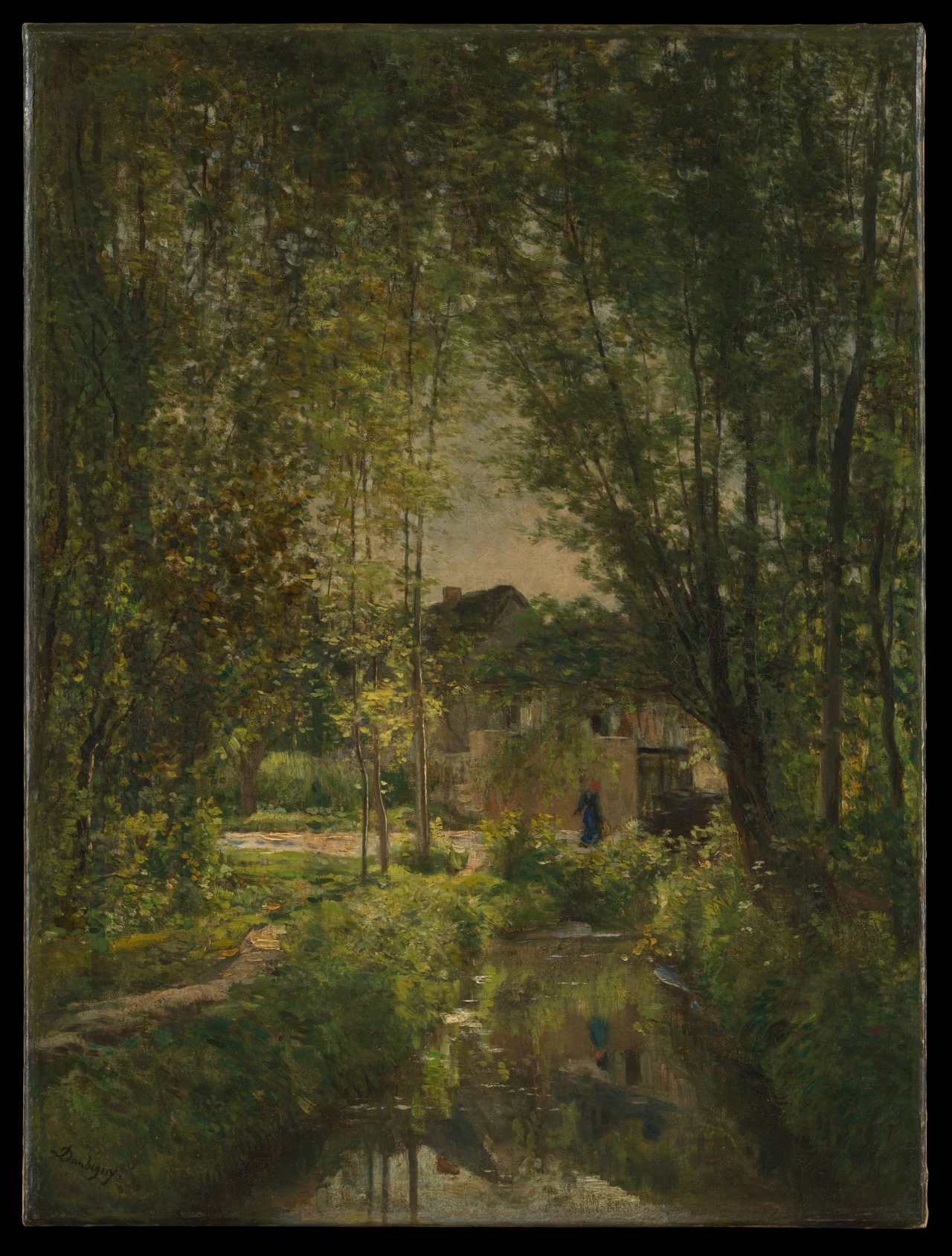 A narrow stream reflects tall trees and a small blue-and-red figure beside a low building in dense green woods.