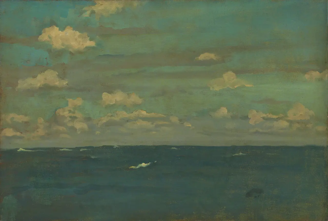 Blue-green water beneath pale clouds, with short white waves near the viewer.