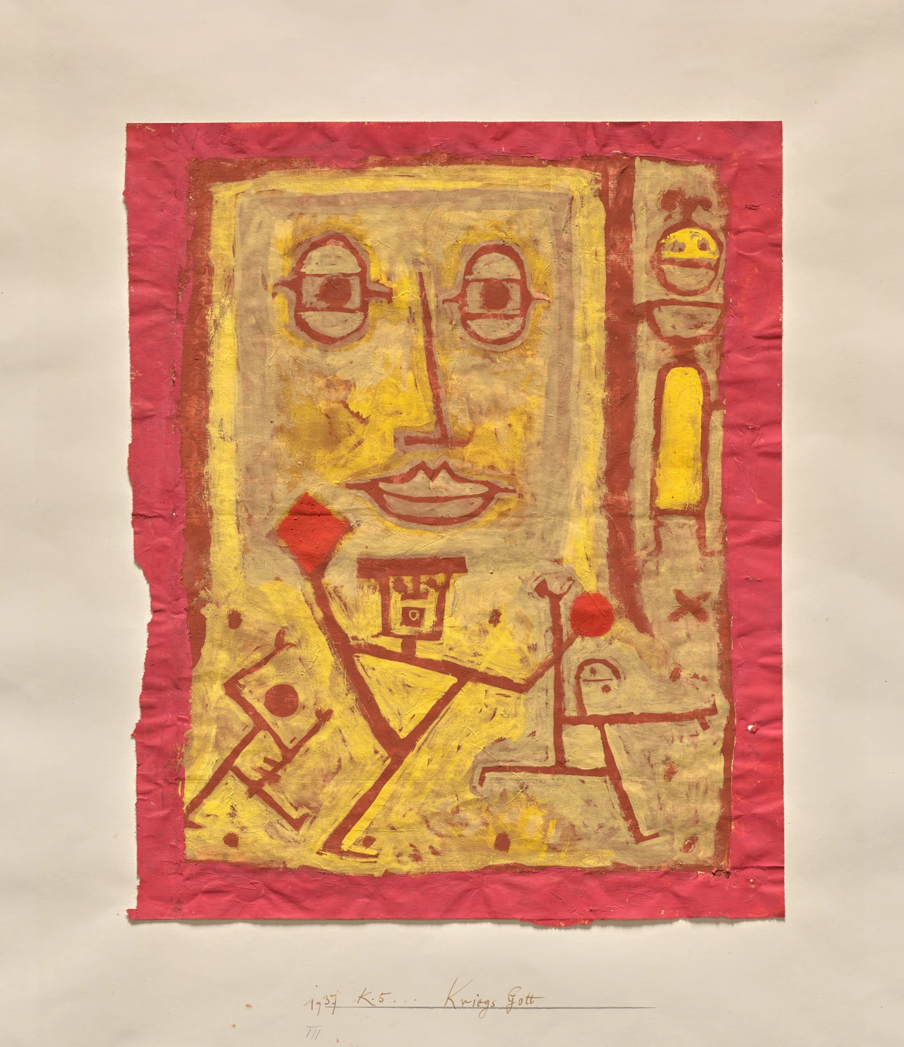 A red and yellow drawing of a large pale face above several small figures and signs on a torn sheet of paper.